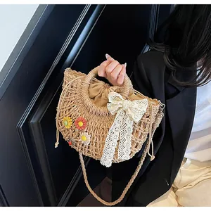 Detail of hand-woven straw bag with 3D flowers, lace bow, and drawstring lining
