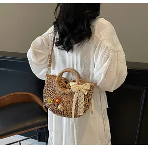 Detail of woven straw bag with floral accents and lace bow on white dress model