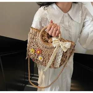 Detail of hand-woven straw bag featuring a large white lace bow and drawstring lining