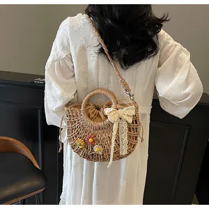 Close-up of straw woven bag with crochet flowers and white lace bow decoration