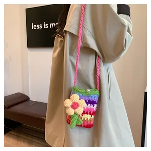 Detailaufnahme einer bunten Häkel-Umhängetasche für Handys mit Blumenanhänger-Verzierung
