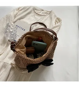 Draufsicht auf Strohtasche mit schwarzer Schleife, zeigt Platz für Handy und Geldbörse