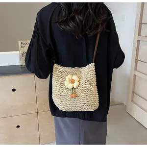 Detailansicht der handgewebten Strohtasche mit Sonnenblume und brauner Quaste