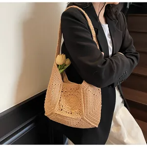 Detailopname van een handgemaakte gehaakte hobo-tas met een decoratief zonnebloempatroon