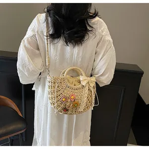 Detailed macro of woven straw handbag with 3D floral accents and a lace bow charm