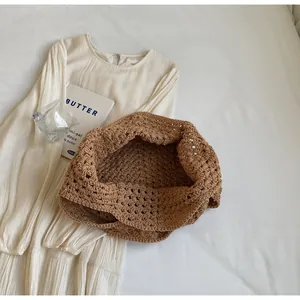Close-up of brown crochet knit tote bag with openwork texture on white fabric