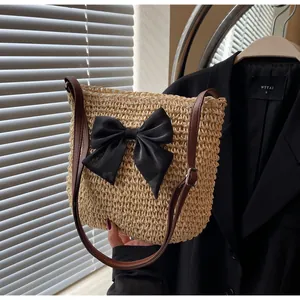 Detailansicht der Strohtasche mit schwarzer Seidenschleife und Lederriemen