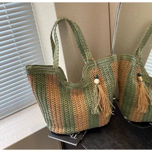 Close-up of a striped woven tote bag featuring decorative wood beads and long tassels