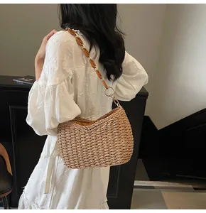 Chic straw woven half-moon bag with amber resin chain strap on white dress