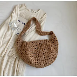 Macro view of textured brown crochet knit pattern on a bohemian style crescent shoulder bag