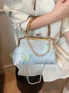 Blue jacquard shell bag with bamboo handle and butterfly embroidery in a sweet retro style