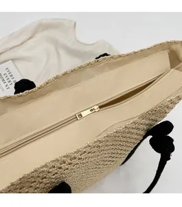 Détail du zip métallique fluide et de la texture en paille tressée du sac de plage