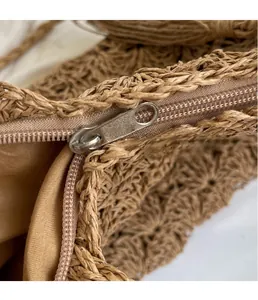 Detailed view of quality metal zipper and woven texture on a summer straw tote bag