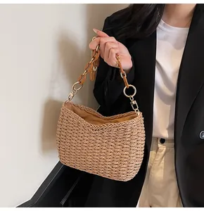 Detail of straw woven bag featuring tortoiseshell acrylic chain and metallic rings