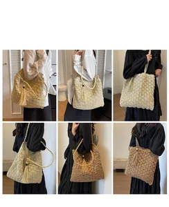 Detail of hollow-out woven pattern and tassel charms on large capacity straw tote bag