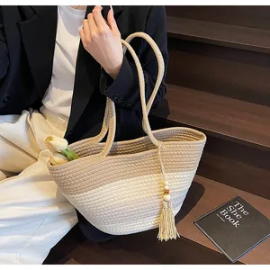Vue détaillée du sac cabas tissé avec des pompons à franges et une texture en coton dégradé