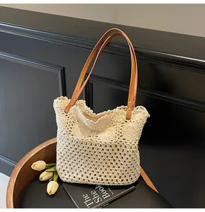 Detailed close-up of handmade hollow crochet tote bag with brown leather handles and rivets