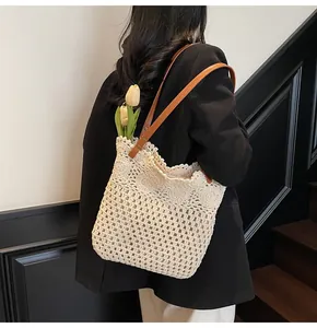 Detail of hollow crochet beach tote with leather straps and delicate woven texture