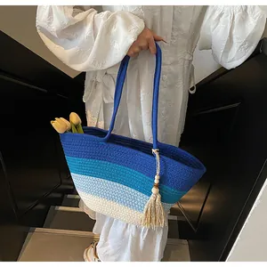 Détail du sac cabas tissé avec rayures dégradées bleues et pompon bohème chic