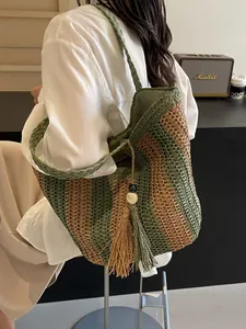 Olive green striped straw tote bag with fringe tassel detail for beach vacations