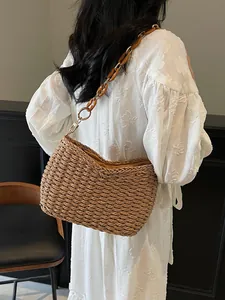 Brown straw woven shoulder bag with amber resin chain strap for beach vacations