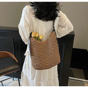 Detail of hand-woven straw shoulder bag with leather strap on vintage white dress