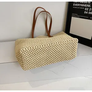 Détail du tissage en paille ajouré et de la bandoulière en cuir de ce sac de plage