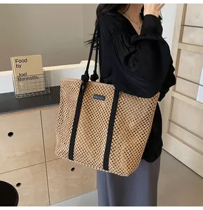 Détail d'un sac cabas en paille tissée avec sangles en toile et poignées en corde