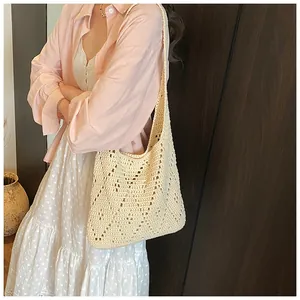 Detail view of beige crochet tote bag with hollow diamond pattern and woven strap