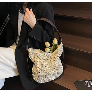 Detail van beige handgeweven hobo-tas met donkerbruine leren riemen voor de zomermode