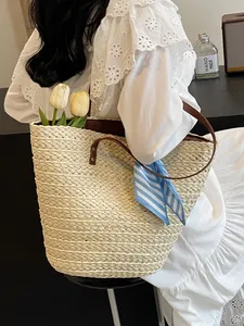 Women's woven straw bucket bag with brown leather straps and blue striped silk scarf