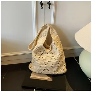 Close-up of the delicate hollow diamond-patterned crochet texture on the cream tote bag
