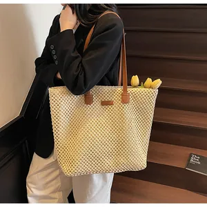 Détail du tissage en paille ajourée et de l'anse en cuir marron de ce sac cabas chic