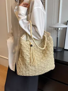Minimalist straw woven tote bag with fringe detail for summer beach vacations