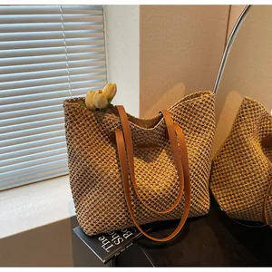 Gros plan du sac fourre-tout en paille avec brides en cuir brun et crochet ajouré