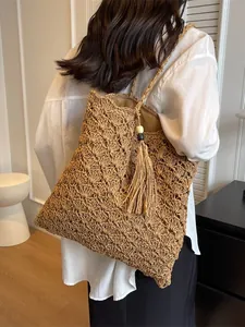 Minimalist straw tote bag with woven hollow texture and tassel for summer beach vacations