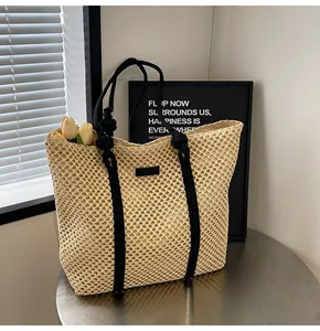 Détail du sac cabas en paille tissée avec anses en corde noire et maille filet