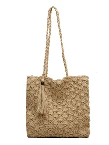 Minimalist straw tote bag with shell texture crochet patterns and a long tassel charm