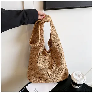 Detailed macro view showing the textured hollow crochet pattern of the khaki knit beach bag