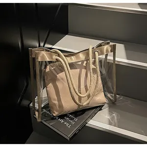 Detail of transparent PVC beach bag with champagne lining and beige rope handles