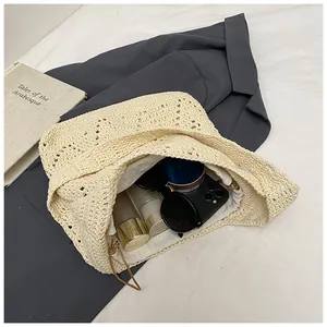 Top view of hollow woven beach bag with inner drawstring pouch and personal items