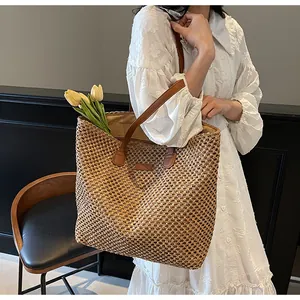 Détail du sac cabas en paille avec anses en cuir marron et grand espace intérieur