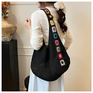 Detail of colorful mandala crochet strap on black knit hobo beach shoulder bag