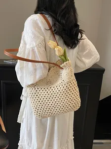 Hollow beige woven tote bag with brown leather strap styled with a white lace dress