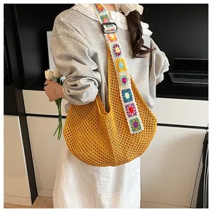 Detail of yellow hollow knit tote bag with colorful crochet floral strap embellishments
