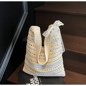 Detailed close-up of striped crochet beach bag featuring delicate lace bow decoration