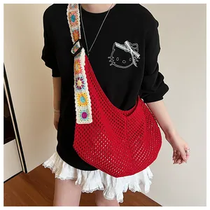 Detail of red hollow crochet shoulder bag with colorful floral embroidery strap