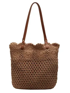 Brown crochet beach tote bag with leather handles and intricate woven hollow design