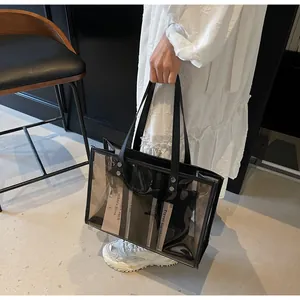 Detail of semi-transparent black PVC tote with leather handles and metallic studs