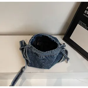 Détail de l'intérieur du sac à bandoulière en jean avec doublure noire et cordon